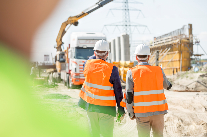 Rear view of supervisors walking at construction site